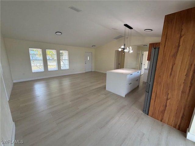 2803 E 5th St, Lehigh Acres, FL 33972 - unfurnished living room with lofted ceiling, a chandelier, light wood-style flooring, and baseboards