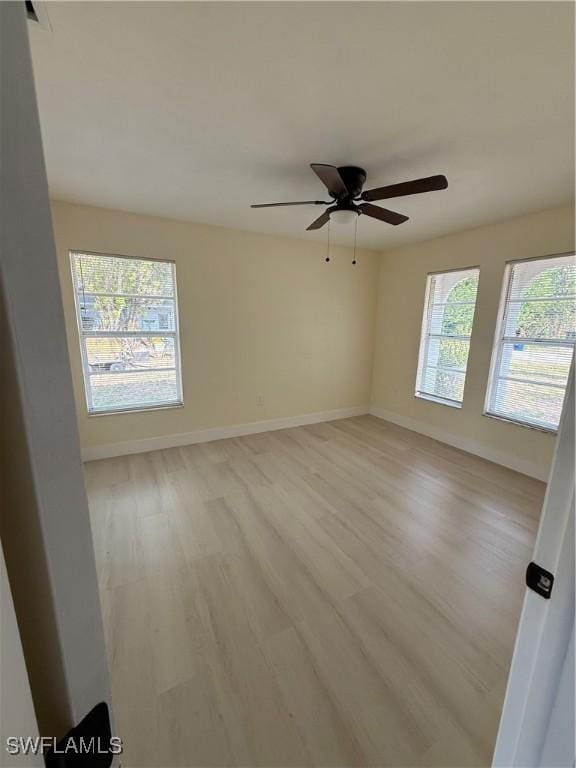 2803 E 5th St, Lehigh Acres, FL 33972 - unfurnished room featuring light wood-style floors, baseboards, and a ceiling fan
