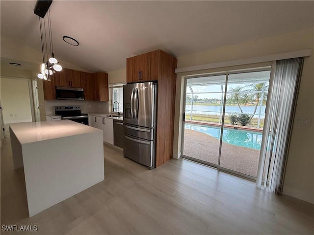 2803 E 5th St, Lehigh Acres, FL 33972 - kitchen with stainless steel appliances, a sink, brown cabinets, light countertops, and a water view