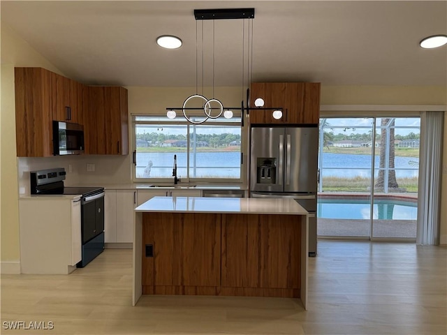 2803 E 5th St, Lehigh Acres, FL 33972 - kitchen featuring stainless steel appliances, a sink, light countertops, and a kitchen island