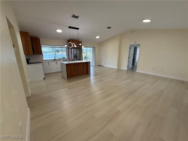 2803 E 5th St, Lehigh Acres, FL 33972 - kitchen featuring stainless steel fridge with ice dispenser, open floor plan, light wood-style floors, a kitchen island, and a chandelier