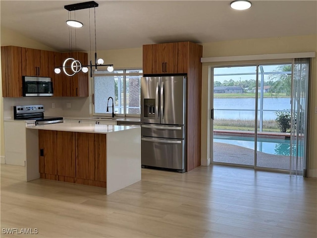 2803 E 5th St, Lehigh Acres, FL 33972 - kitchen with stainless steel appliances, brown cabinetry, a sink, a center island, and light wood-style flooring
