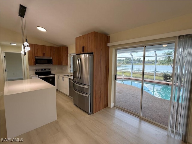 2803 E 5th St, Lehigh Acres, FL 33972 - kitchen with stainless steel appliances, brown cabinetry, light countertops, a water view, and pendant lighting