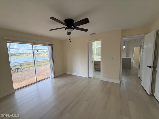 2803 E 5th St, Lehigh Acres, FL 33972 - unfurnished room featuring a water view, ceiling fan, light wood finished floors, and baseboards