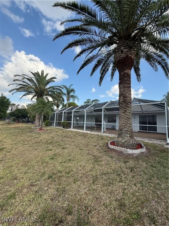 2803 E 5th St, Lehigh Acres, FL 33972 - view of green lawn with glass enclosure