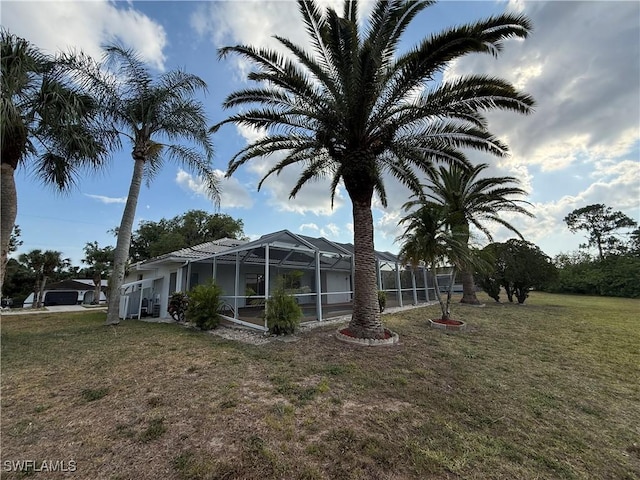 2803 E 5th St, Lehigh Acres, FL 33972 - view of side of home with a lawn and glass enclosure