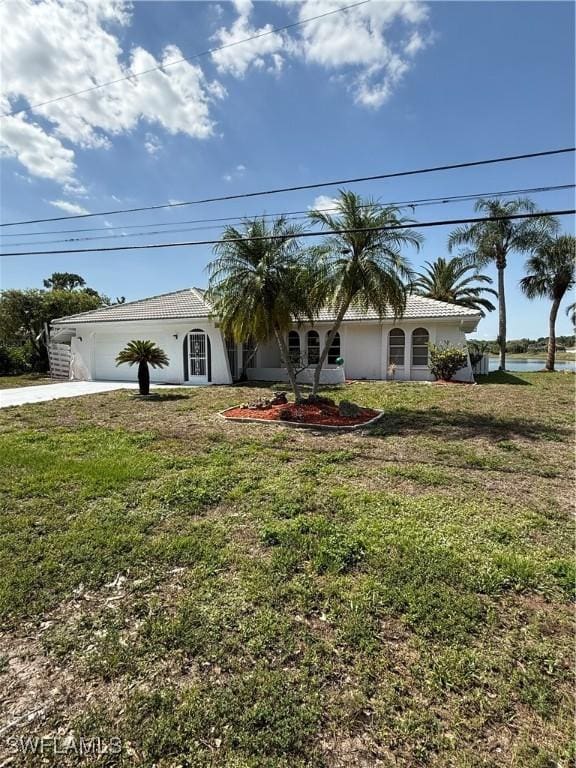 2803 E 5th St, Lehigh Acres, FL 33972 - single story home featuring concrete driveway, a garage, a front yard, stucco siding, and a tiled roof