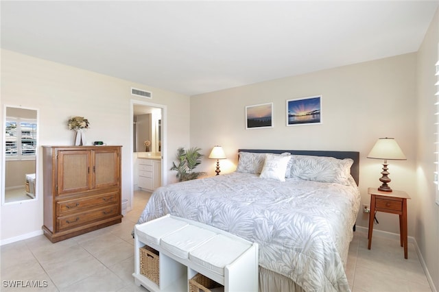 860 Panama Ct Unit 107, Marco Island, FL 34145 - bedroom with light tile patterned floors, baseboards, and ensuite bathroom