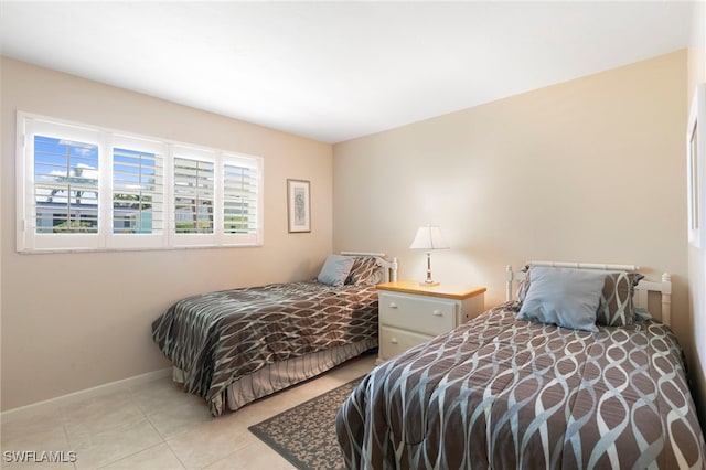860 Panama Ct Unit 107, Marco Island, FL 34145 - bedroom with light tile patterned floors and baseboards