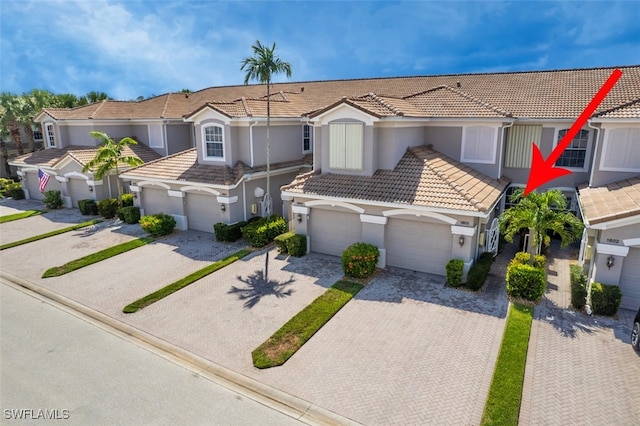 10011 Sky View Way Unit 1803, Fort Myers, FL 33913 - view of front facade featuring a tiled roof, driveway, stucco siding, and an attached garage