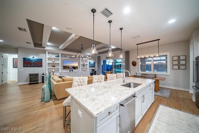 14372 Neptune Ave, Naples, FL 34114 - kitchen featuring a sink, stainless steel dishwasher, a kitchen bar, white cabinets, and baseboards