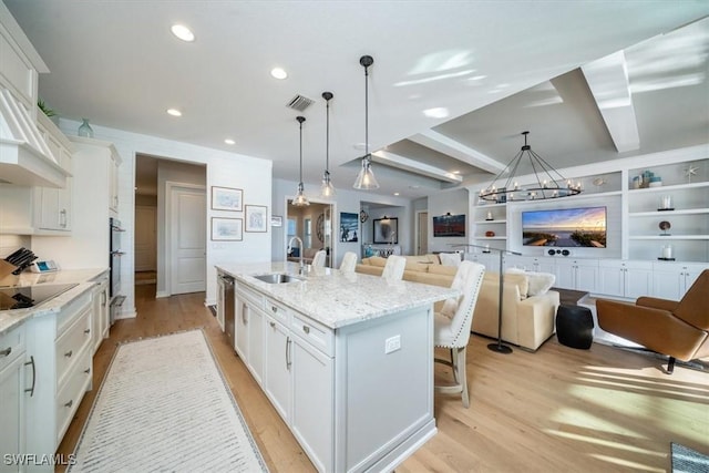 14372 Neptune Ave, Naples, FL 34114 - kitchen with a sink, open floor plan, a kitchen bar, white cabinets, and an island with sink