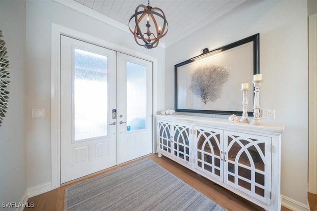 14372 Neptune Ave, Naples, FL 34114 - foyer entrance featuring french doors, wood finished floors, a chandelier, and baseboards