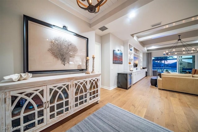 14372 Neptune Ave, Naples, FL 34114 - hallway featuring a chandelier, light wood-type flooring, baseboards, beam ceiling, and ornamental molding