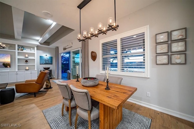 14372 Neptune Ave, Naples, FL 34114 - dining space with a chandelier, light wood-style floors, baseboards, and built in shelves