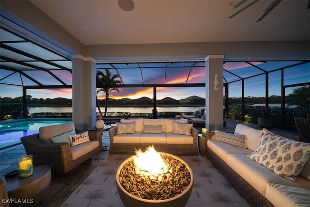 14372 Neptune Ave, Naples, FL 34114 - patio terrace at dusk with an outdoor living space with a fire pit, a lanai, a patio area, and an outdoor pool