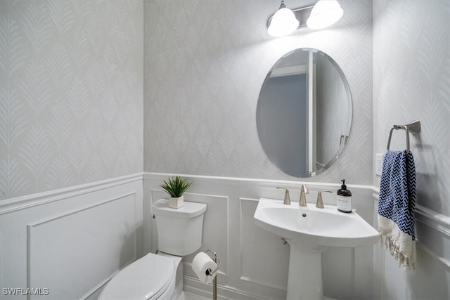14372 Neptune Ave, Naples, FL 34114 - half bathroom with wallpapered walls, toilet, a wainscoted wall, and a decorative wall