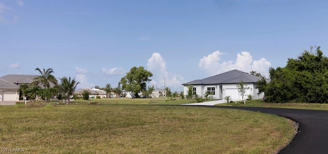 17211 Nile Ct, Punta Gorda, FL 33955 - view of front facade featuring asphalt driveway, a garage, and a front lawn