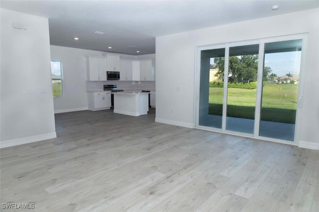 17211 Nile Ct, Punta Gorda, FL 33955 - unfurnished living room featuring light wood finished floors, baseboards, and recessed lighting