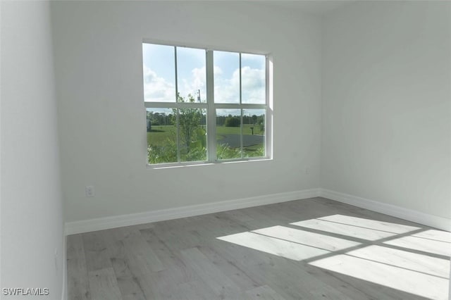 17211 Nile Ct, Punta Gorda, FL 33955 - empty room featuring plenty of natural light, wood finished floors, and baseboards
