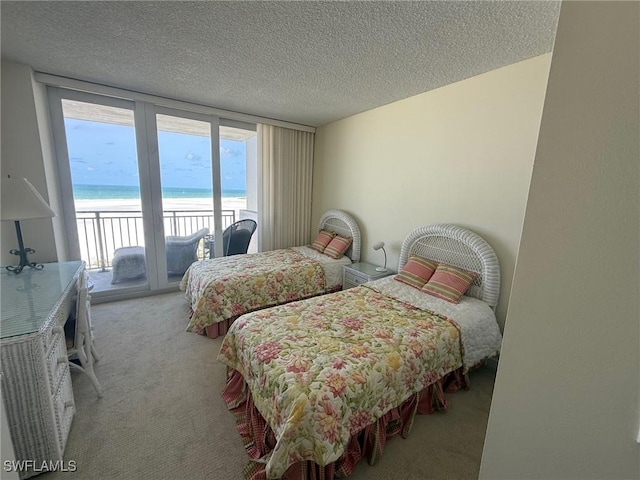 180 Seaview Ct Unit 715, Marco Island, FL 34145 - carpeted bedroom featuring access to exterior, a textured ceiling, and view of water and beach