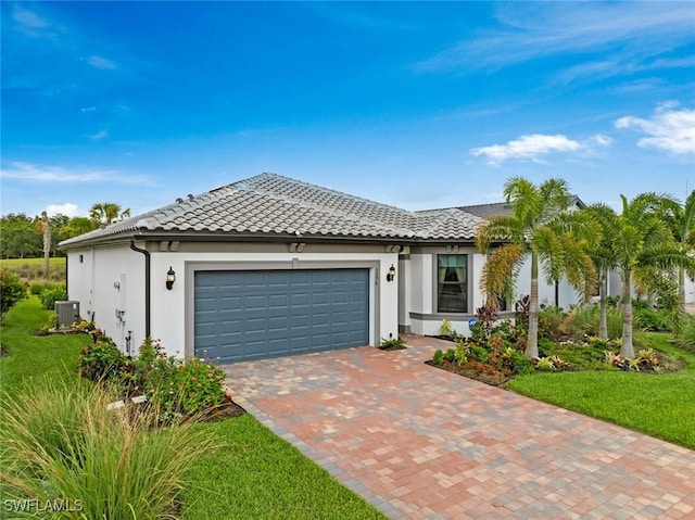 5596 Celebration Dr, Ave Maria, FL 34142 - view of front of home featuring an attached garage, stucco siding, central AC unit, and decorative driveway