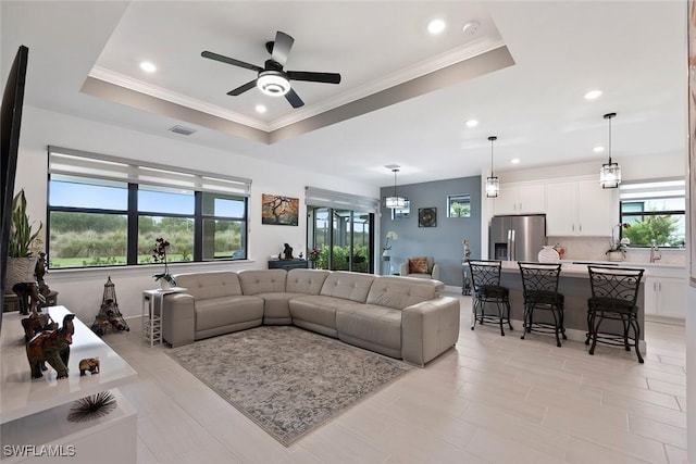 5596 Celebration Dr, Ave Maria, FL 34142 - living room featuring plenty of natural light, a tray ceiling, a ceiling fan, recessed lighting, and ornamental molding