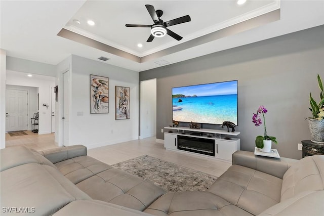 5596 Celebration Dr, Ave Maria, FL 34142 - living area featuring a tray ceiling, recessed lighting, a ceiling fan, crown molding, and baseboards