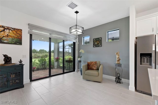 5596 Celebration Dr, Ave Maria, FL 34142 - living area with plenty of natural light, a chandelier, baseboards, and light tile patterned floors