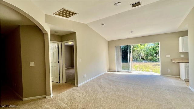 4532/4534 29th St SW, Lehigh Acres, FL 33973 - empty room with light carpet, arched walkways, vaulted ceiling, and baseboards