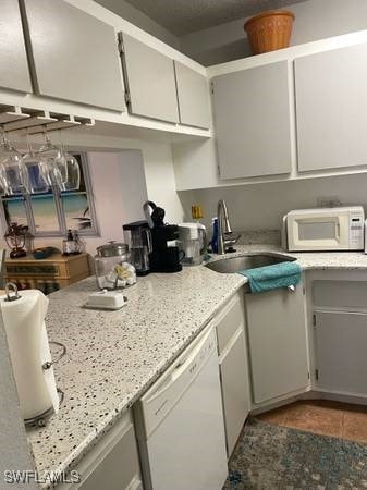 9610 Green Cypress Ln Unit 4, Fort Myers, FL 33905 - kitchen with white appliances, a sink, tile patterned floors, and light stone counters