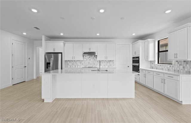 6600 Legacy Way, Ave Maria, FL 34142 - kitchen with stainless steel fridge, under cabinet range hood, light countertops, tasteful backsplash, and recessed lighting