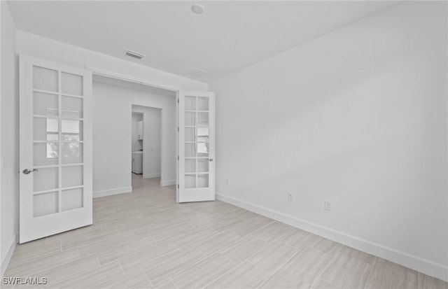 6600 Legacy Way, Ave Maria, FL 34142 - unfurnished room featuring french doors, baseboards, and washer / dryer