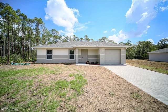 130 Sanborn Dr, Lehigh Acres, FL 33972 - ranch-style home with a garage, decorative driveway, and stucco siding