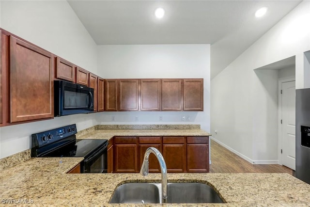 1205 SW 32nd Ter, Cape Coral, FL 33914 - kitchen with black appliances, a sink, wood finished floors, baseboards, and recessed lighting