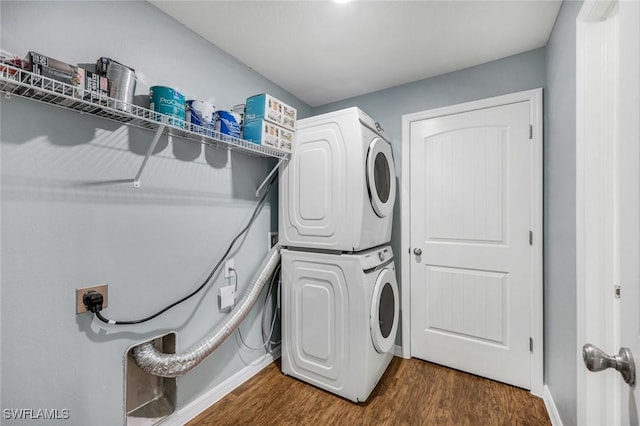 1205 SW 32nd Ter, Cape Coral, FL 33914 - laundry area with stacked washing machine and dryer, dark wood finished floors, and baseboards