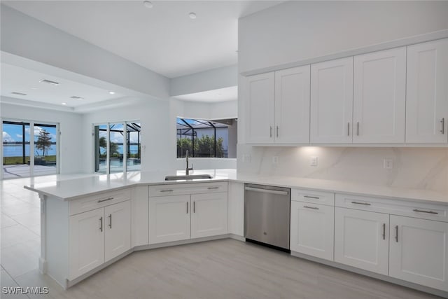 17236 Blue Sapphire Dr, Fort Myers, FL 33913 - kitchen with dishwasher, a peninsula, a sink, light countertops, and white cabinets