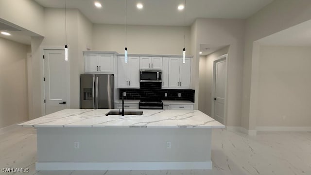 4619 7th St W, Lehigh Acres, FL 33971 - kitchen featuring stainless steel appliances, a sink, a center island with sink, backsplash, and white cabinetry