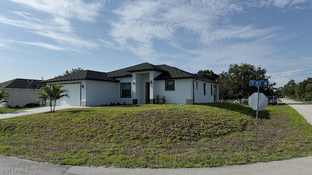 4619 7th St W, Lehigh Acres, FL 33971 - view of front of property with concrete driveway, an attached garage, a front lawn, and stucco siding