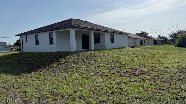4619 7th St W, Lehigh Acres, FL 33971 - back of property featuring a lawn and stucco siding