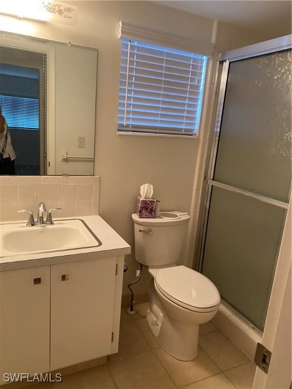 1515 Tropic Ter Unit 1515, North Fort Myers, FL 33903 - bathroom with vanity, toilet, tile patterned floors, and a stall shower