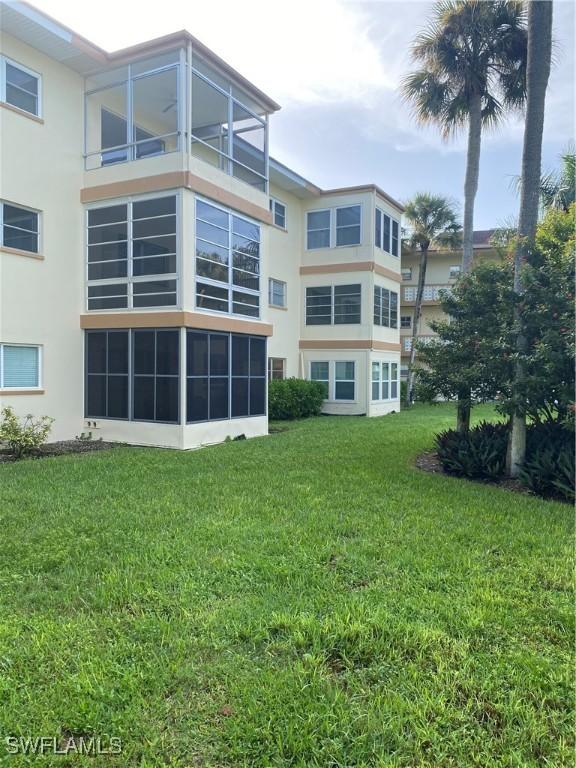 1515 Tropic Ter Unit 1515, North Fort Myers, FL 33903 - rear view of house with stucco siding and a lawn