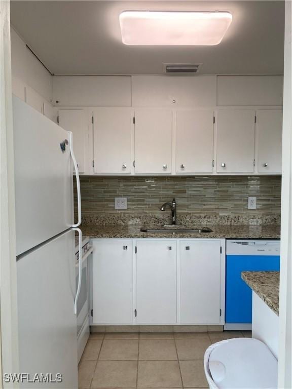 1515 Tropic Ter Unit 1515, North Fort Myers, FL 33903 - kitchen with white appliances, a sink, light tile patterned floors, white cabinets, and tasteful backsplash