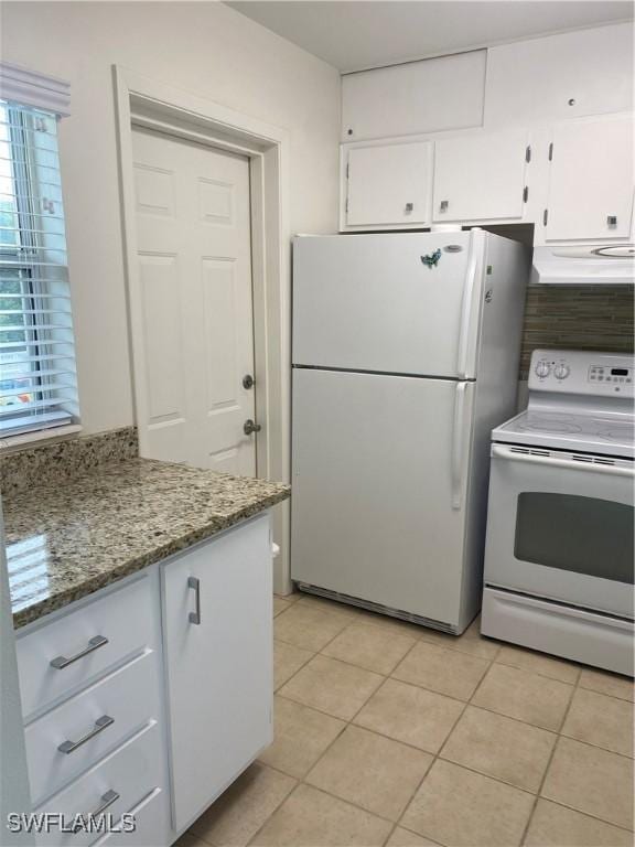 1515 Tropic Ter Unit 1515, North Fort Myers, FL 33903 - kitchen with white appliances, white cabinetry, light tile patterned floors, exhaust hood, and light stone counters