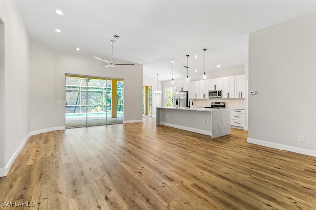 3519 Heron Cove Ct, Bonita Springs, FL 34134 - unfurnished living room featuring healthy amount of natural light, light wood-style flooring, recessed lighting, and baseboards