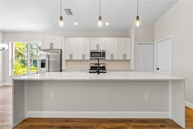 3519 Heron Cove Ct, Bonita Springs, FL 34134 - kitchen featuring stainless steel appliances, a spacious island, light stone counters, and pendant lighting