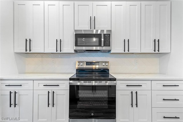 3519 Heron Cove Ct, Bonita Springs, FL 34134 - kitchen featuring appliances with stainless steel finishes, tasteful backsplash, light stone countertops, and white cabinetry