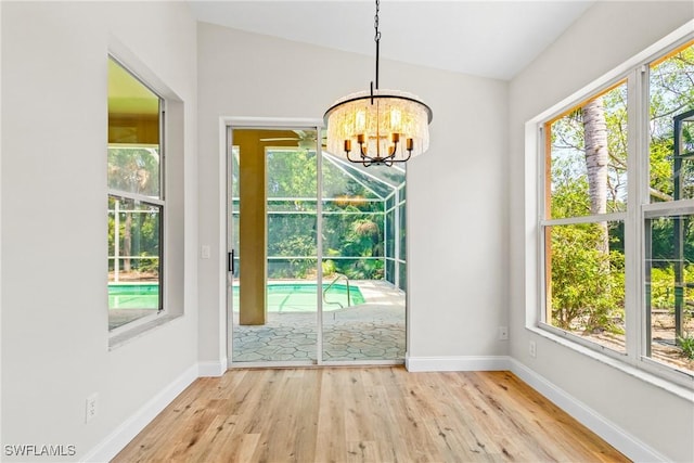3519 Heron Cove Ct, Bonita Springs, FL 34134 - unfurnished dining area with a chandelier, wood finished floors, and healthy amount of natural light