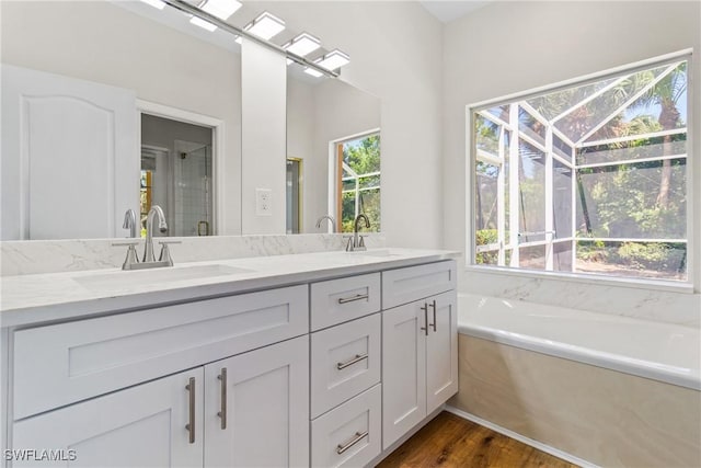 3519 Heron Cove Ct, Bonita Springs, FL 34134 - full bath with double vanity, a bath, wood finished floors, and a shower with shower door
