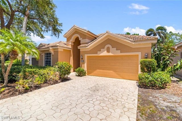 3519 Heron Cove Ct, Bonita Springs, FL 34134 - mediterranean / spanish-style home featuring stucco siding, an attached garage, decorative driveway, and a tile roof